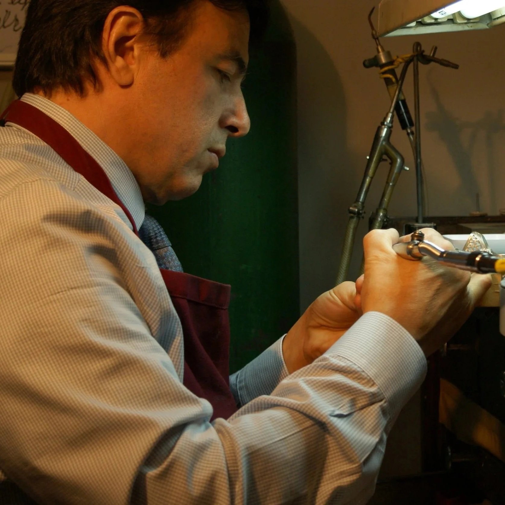 Master jeweler Albert Kaz meticulously handcrafting a custom engagement ring at Kaz Jewelry, showcasing precision and artistry